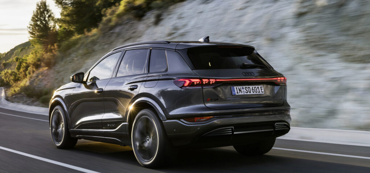 SUV on the road at dusk. Rear taillights illuminaged.